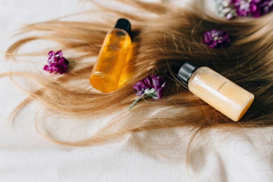 Aceites esenciales y flores sobre tela clara