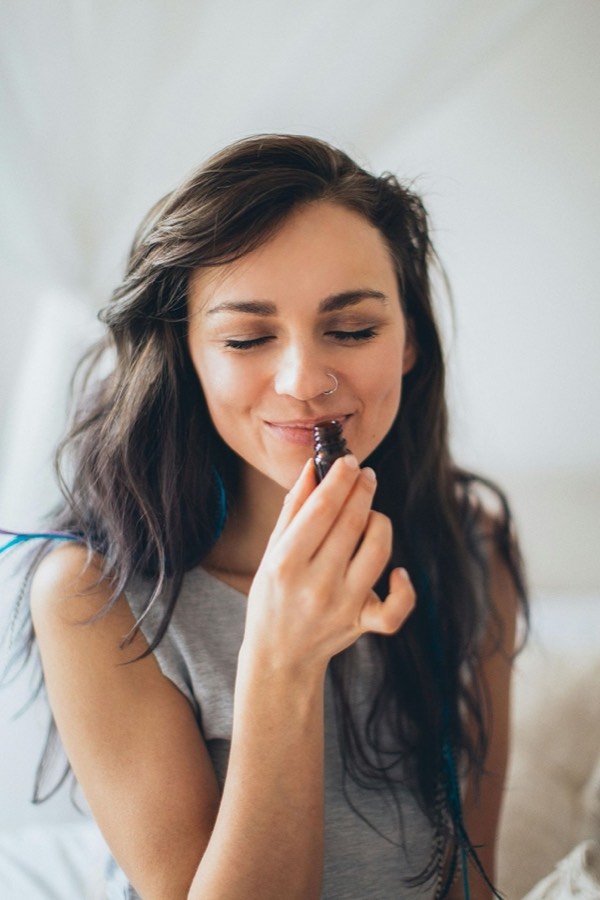 Mujer percibiendo el aroma de un producto cosmético